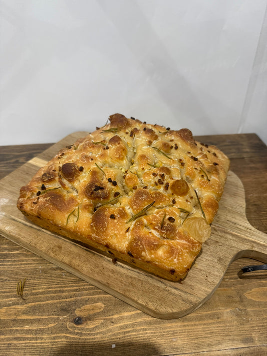 Garlic and rosemary foccacia on a wooden chopping board.